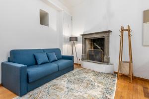 a blue couch in a living room with a fireplace at BeRGAMO ALTA - Piazza Mercato del Fieno HOUSE in Bergamo