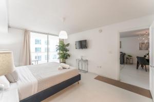 una camera bianca con un grande letto e un soggiorno di Lux Brickell Bay Condo City Views & Prime Location a Miami Altre 13 foto