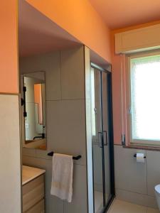 a bathroom with a shower and a sink and a mirror at Palma 12 in Lignano Sabbiadoro