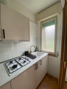 a kitchen with a stove and a sink and a window at Palma 12 in Lignano Sabbiadoro