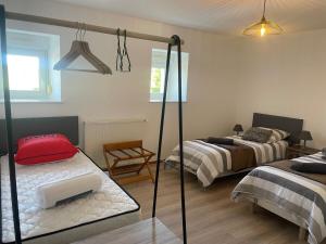 a bedroom with two beds and a room with a mirror at Chez Paul in Jeuxey