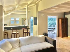 a living room with a couch and a kitchen at Villa martinique in Sainte-Luce