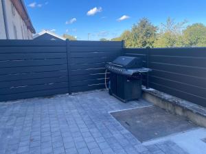 a trash can sitting in front of a fence at Chez Paul in Jeuxey