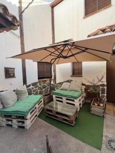 a patio with two beds and an umbrella at Casa Rural El PARADOR in Carcelén