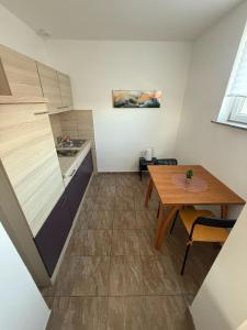 eine kleine Küche mit einem Holztisch und einem Tisch sowie ein Esszimmer in der Unterkunft Sobe Ježdovec in Ježdovec