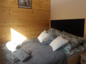 a bedroom with a bed with pillows on it at Domki na Stodoliskach in Kasinka Mala