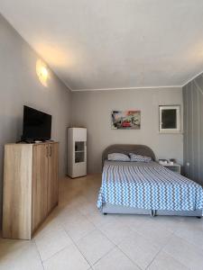 Un dormitorio con una cama y un televisor. en Altura Rooms & Apartments, en Neum