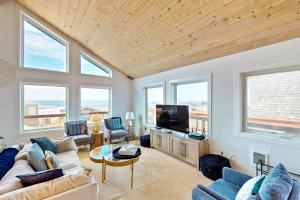 a living room with a couch and a tv at The Kiwanda Surf House in Pacific City