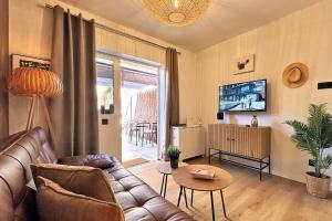 a living room with a couch and a tv at Cosy Bungalow Green Oasis in Maspalomas
