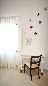 a chair in front of a white wall with shoes on the wall at La Corte nel Vico in Leverano