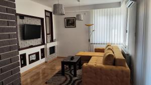 a living room with a couch and a brick wall at Apartmani Stanković in Vranje
