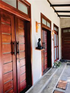 twee deuren van een huis met een kat op een richel bij Casa Luna Weligama in Weligama