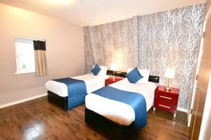 a hotel room with two beds and a window at The Royal Hotel Cardiff in Cardiff