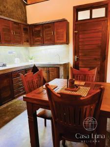 een keuken met een houten tafel en houten kasten bij Casa Luna Weligama in Weligama