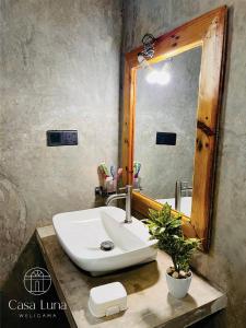 een badkamer met een wastafel en een spiegel bij Casa Luna Weligama in Weligama