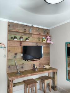 a room with a wooden wall with a tv at Guaratuba Com Piscina , 50 praia in Guaratuba +30 photos