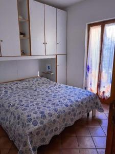 a bedroom with a bed with a blue and white blanket at Rifugio Tavolara in San Teodoro