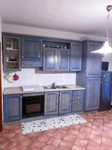 a kitchen with blue cabinets and a stove top oven at Rifugio Tavolara in San Teodoro