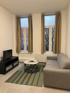 a living room with a couch and a coffee table at Apartment Close to Zuid Park in Antwerp