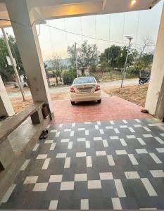 a car parked in a garage with a checkered floor at R K Guest House Nimbi in Jaipur +3 photos