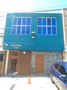 a blue building with a car parked in front of it at Comfort Home Escalón in San Salvador