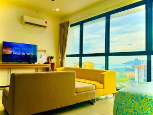 sala de estar con sofá amarillo y TV en Perfect for Groups! 2BR with 5 Queen Beds & WiFi, en Jelutong