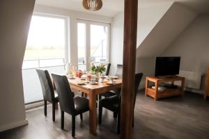 a dining room with a table with chairs and a television at Sonnenblume in Fehmarn