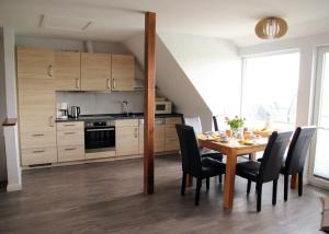 eine Küche und ein Esszimmer mit Tisch und Stühlen in der Unterkunft Sonnenblume in Fehmarn