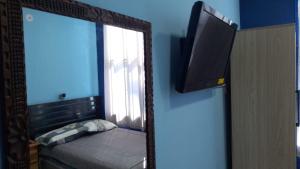 a mirror in a room with a bed and a window at Comfort Home Escalón in San Salvador