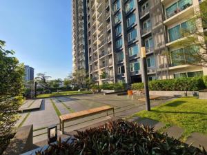 a park with benches in front of a building at Comfortable Zone in Klong Toi