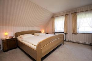a bedroom with a large bed and two windows at Kastanie in Fehmarn