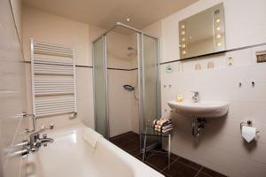 a bathroom with a tub and a sink and a shower at Kastanie in Fehmarn +3 photos