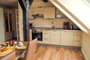 a kitchen with a wooden table and a dining room at Rose in Fehmarn