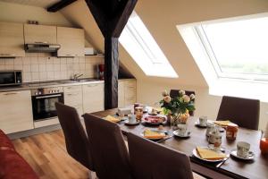 einen Esstisch mit Stühlen und eine Küche mit Oberlichtern in der Unterkunft Rose in Fehmarn