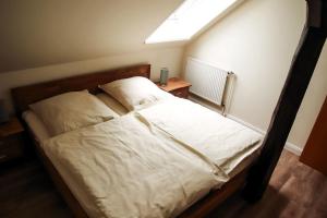 Schlafzimmer mit einem weißen Bett und einem Dachfenster in der Unterkunft Rose in Fehmarn