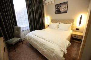 a bedroom with a white bed and a window at Sem Brand Hotel in Türkistan +14 photos