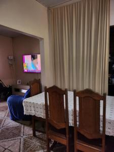 Un comedor con mesa y sillas y un televisor. en Casa para Cop 30, en Ananindeua