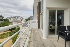 een balkon van een huis met een tafel en stoelen bij Rivoli in Pornichet