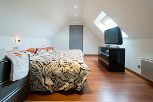 een slaapkamer met een bed en een flatscreen-tv bij Rivoli in Pornichet