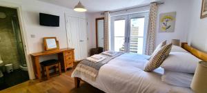 ein Schlafzimmer mit einem großen weißen Bett und einem Fenster in der Unterkunft No 1 Oceans in Perranporth