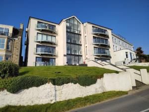 ein Mehrfamilienhaus mit einer Rasenfläche davor in der Unterkunft No 1 Oceans in Perranporth