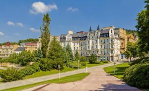 duży budynek z ścieżką przed nim w obiekcie Sun Palace Wellness Hotel w Mariańskich Łaźniach