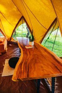 a wooden table in front of a tent at Eco Luxe Glamping Nest #3 - 2 Queen Beds at Holos in Barú