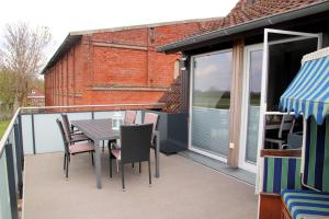 a patio with a table and chairs on a balcony at Gänseblümchen in Fehmarn +8 photos