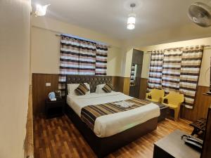 a bedroom with a large bed and a table and chairs at KG Tusheta - 200 mtrs from MG Marg in Gangtok