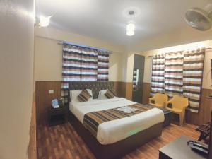 a bedroom with a bed and a desk and a chair at KG Tusheta - 200 mtrs from MG Marg in Gangtok +16 photos