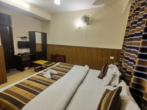 a hotel room with a large bed and a desk at KG Tusheta - 200 mtrs from MG Marg in Gangtok