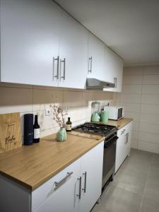 a kitchen with white cabinets and a stove top oven at Casa do Pedro, Quinta Vale de Vila in São João da Pesqueira