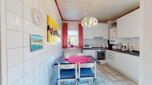 a kitchen with a table and two chairs in it at Strandhöhle in Borkum