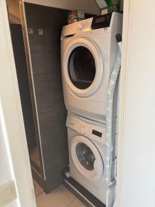 a washing machine and a washer in a closet at Bright studio close to everything! in Brussels +3 photos